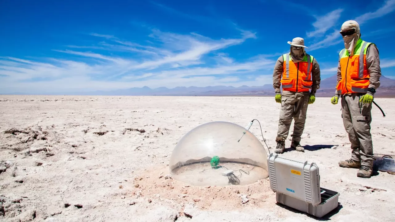 Two men in uniform on the Salar with testing equipment.