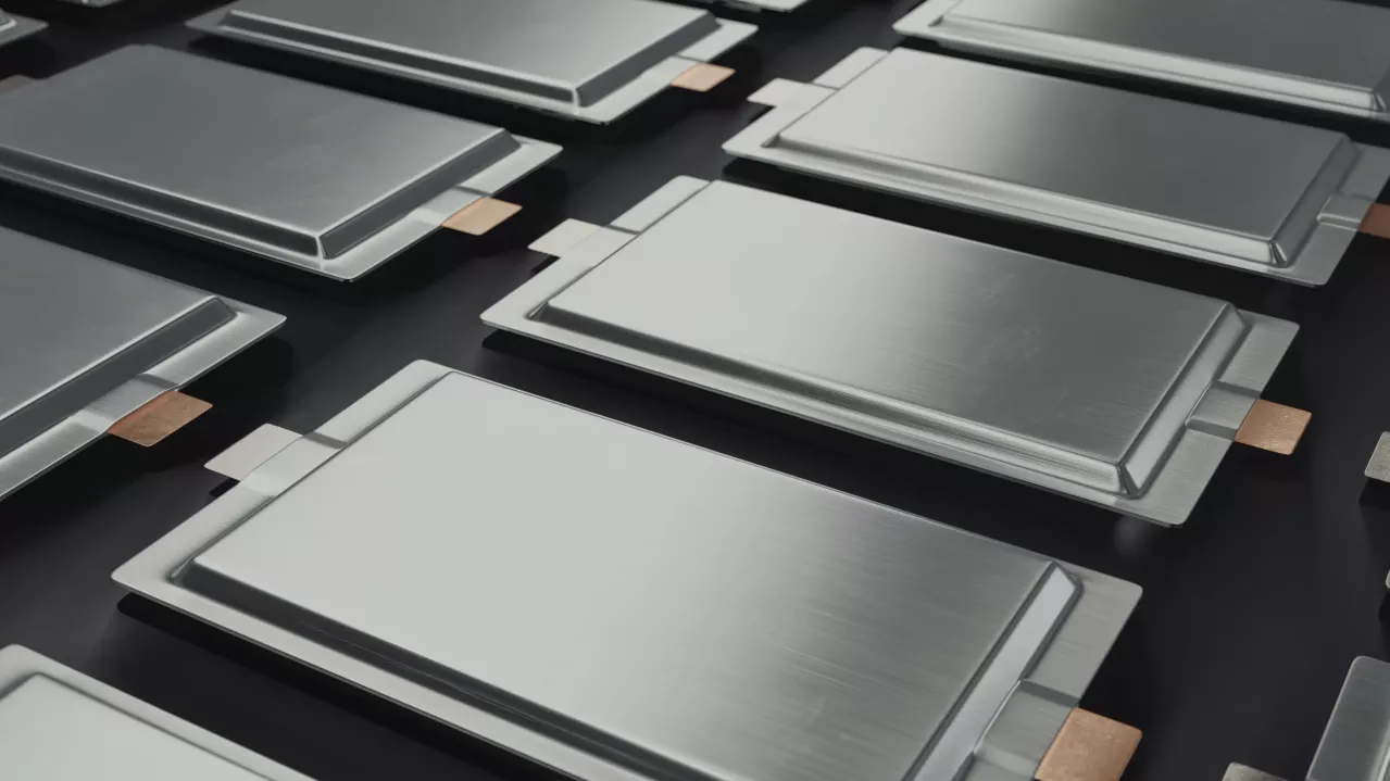 Multiple battery packs with metallic casings arranged neatly on a dark surface, highlighting their sleek design and copper connectors.