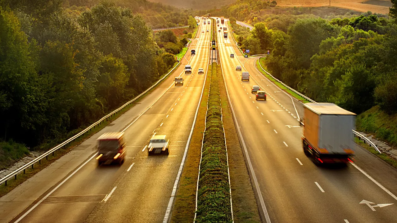An aerial view of a highway with moving traffic.