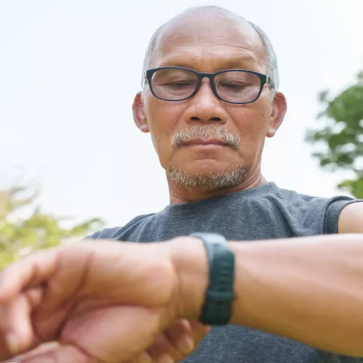 A man checking his smartwatch outdoors, focusing on the screen.